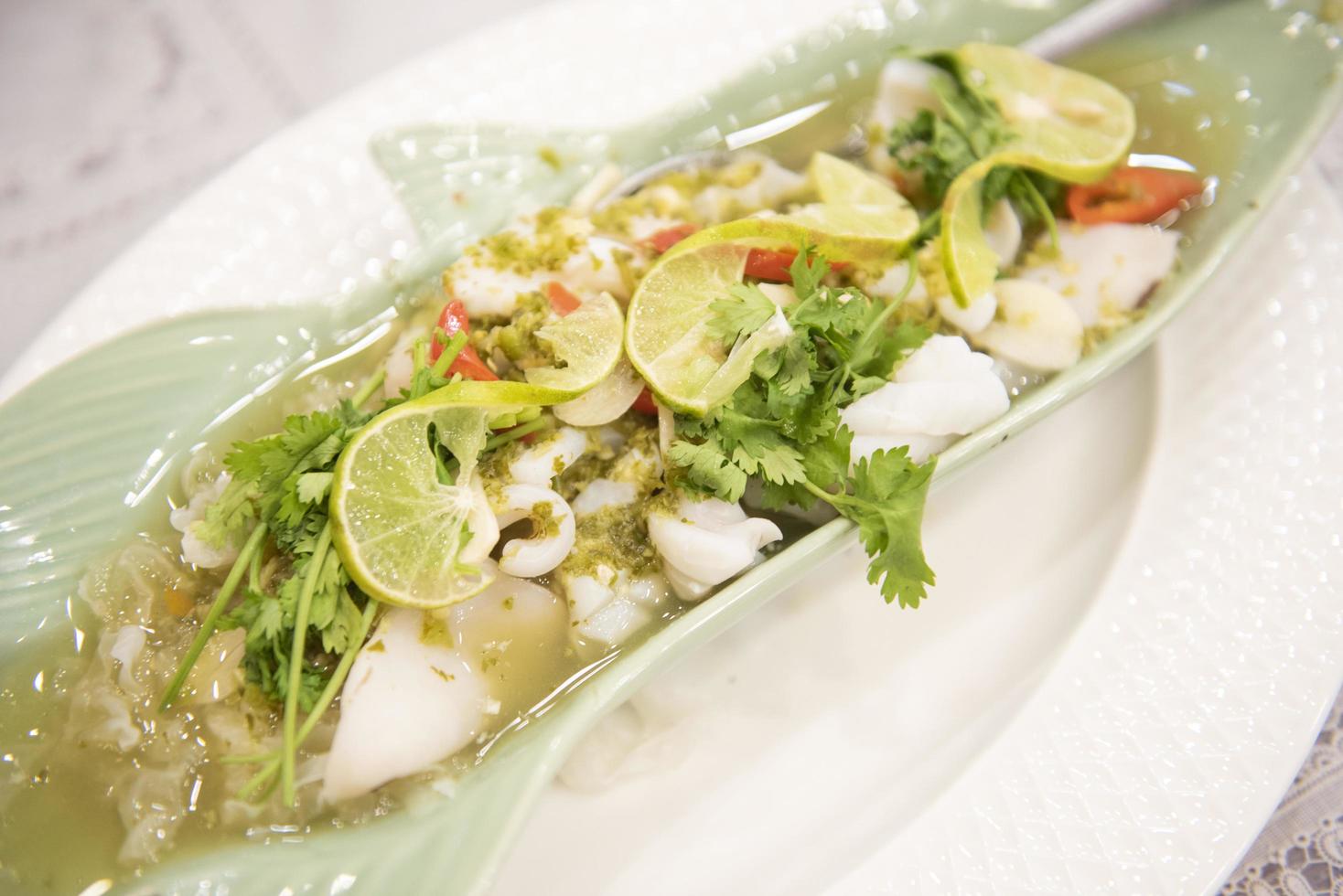 Steamed Squid with Lemon, hot and spicy squid steamed with lime - Thai food photo