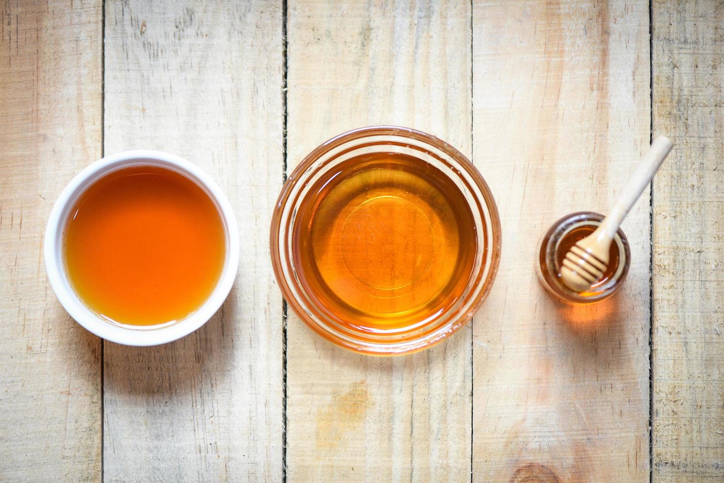 Honey in jar with wooden dipper on wooden background honey cup photo