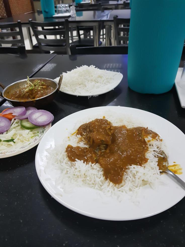 Mutton satay is traditional food in India. grilled with soy sauce and peanut sauce. with rice on the side. with tomatoes and onions topping. photo