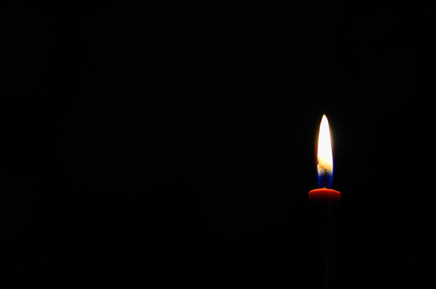 red burning candle in the night during war photo