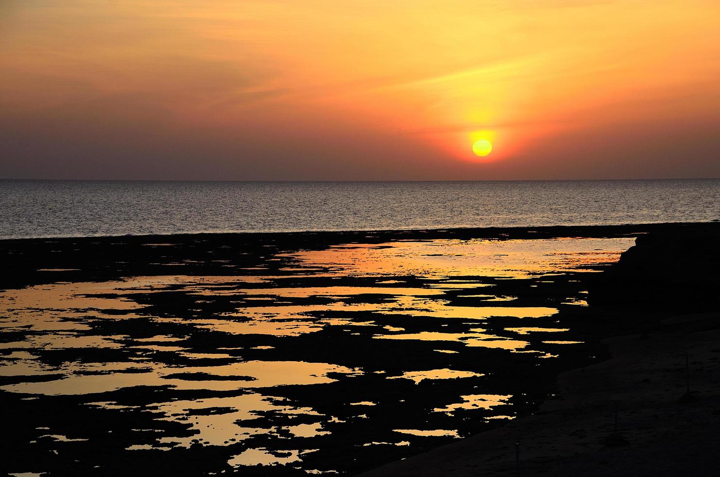 sunrise on sea with reflections on the beach photo