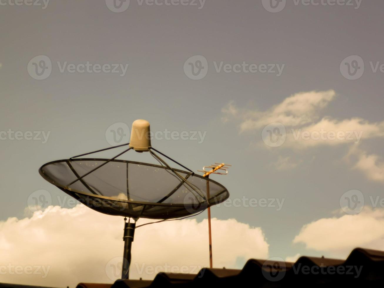 TV satellite dish on the roof of the house in the evening photo