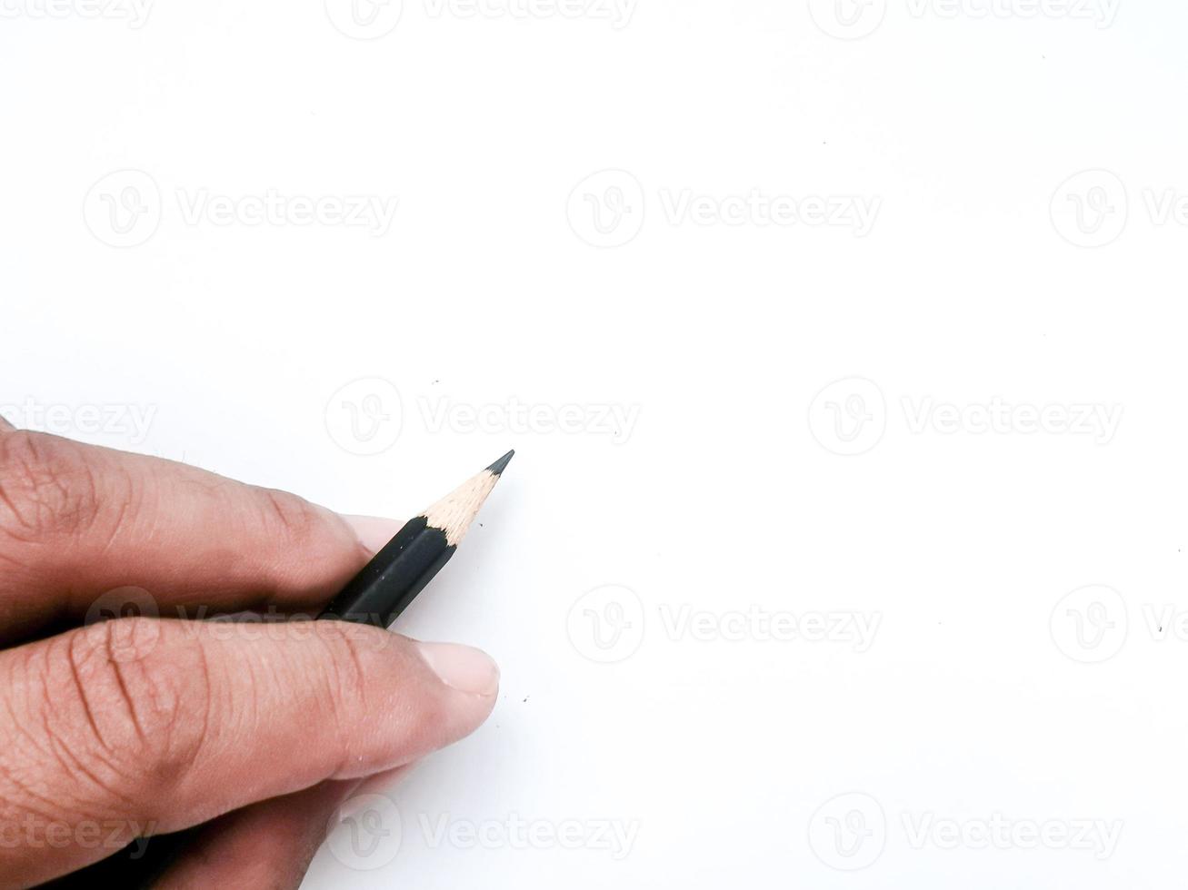 hand holding a black pencil ready to write something on paper photo