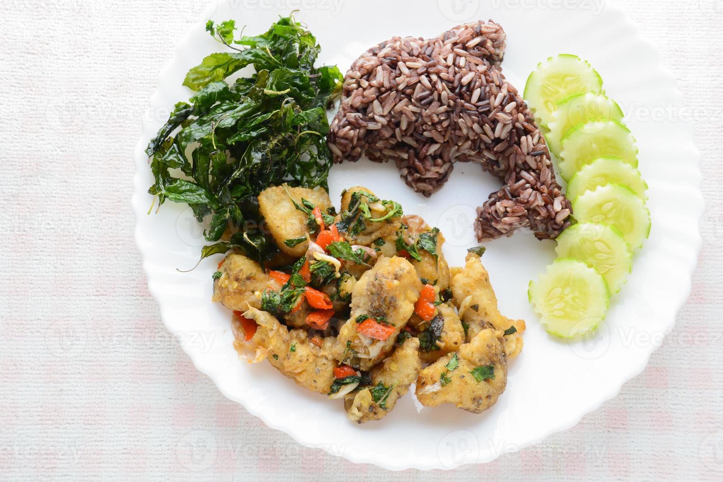 Stir fried fish with chili and basil, served with steamed rice and cucumber, hot and spicy dish. photo