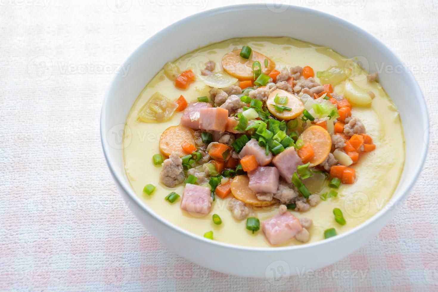 Steamed egg custard cuisine in a white bowl with minced pork, sausage and bacon.  Or Only with egg, water, salt and some sesame oil, you can make this super smooth custard at home. photo