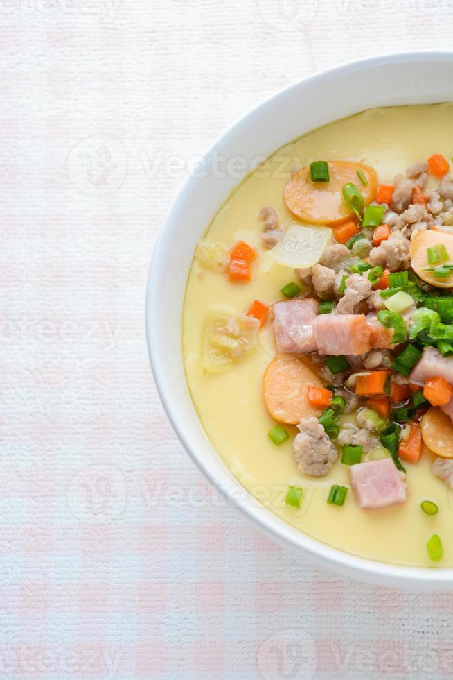 Steamed egg custard cuisine in a white bowl with minced pork, sausage and bacon.  Or Only with egg, water, salt and some sesame oil, you can make this super smooth custard at home. photo