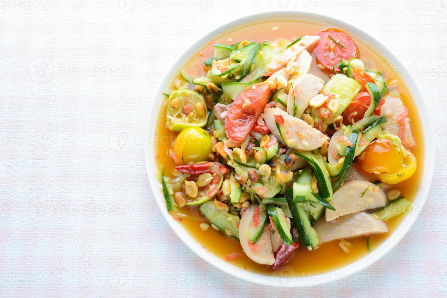 Ensalada de pepino con salchichas de cerdo en conserva, comida popular tailandesa llamada som tum tang, verduras mixtas calientes y picantes. foto