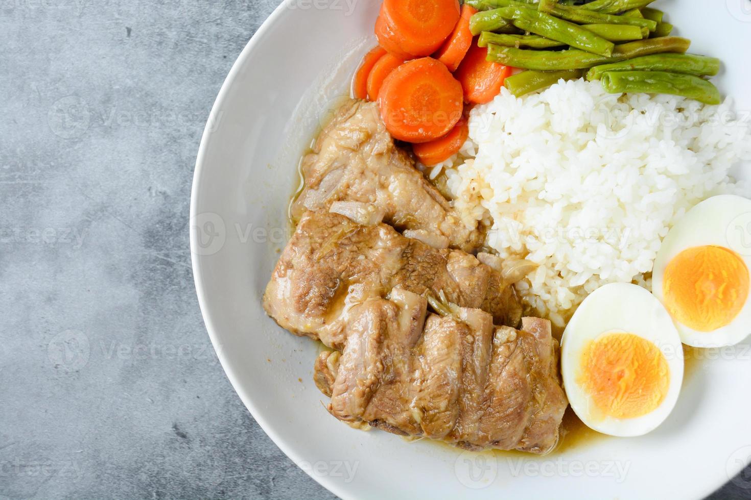 Baked pork ribs with rice, boiled egg and vegetable photo