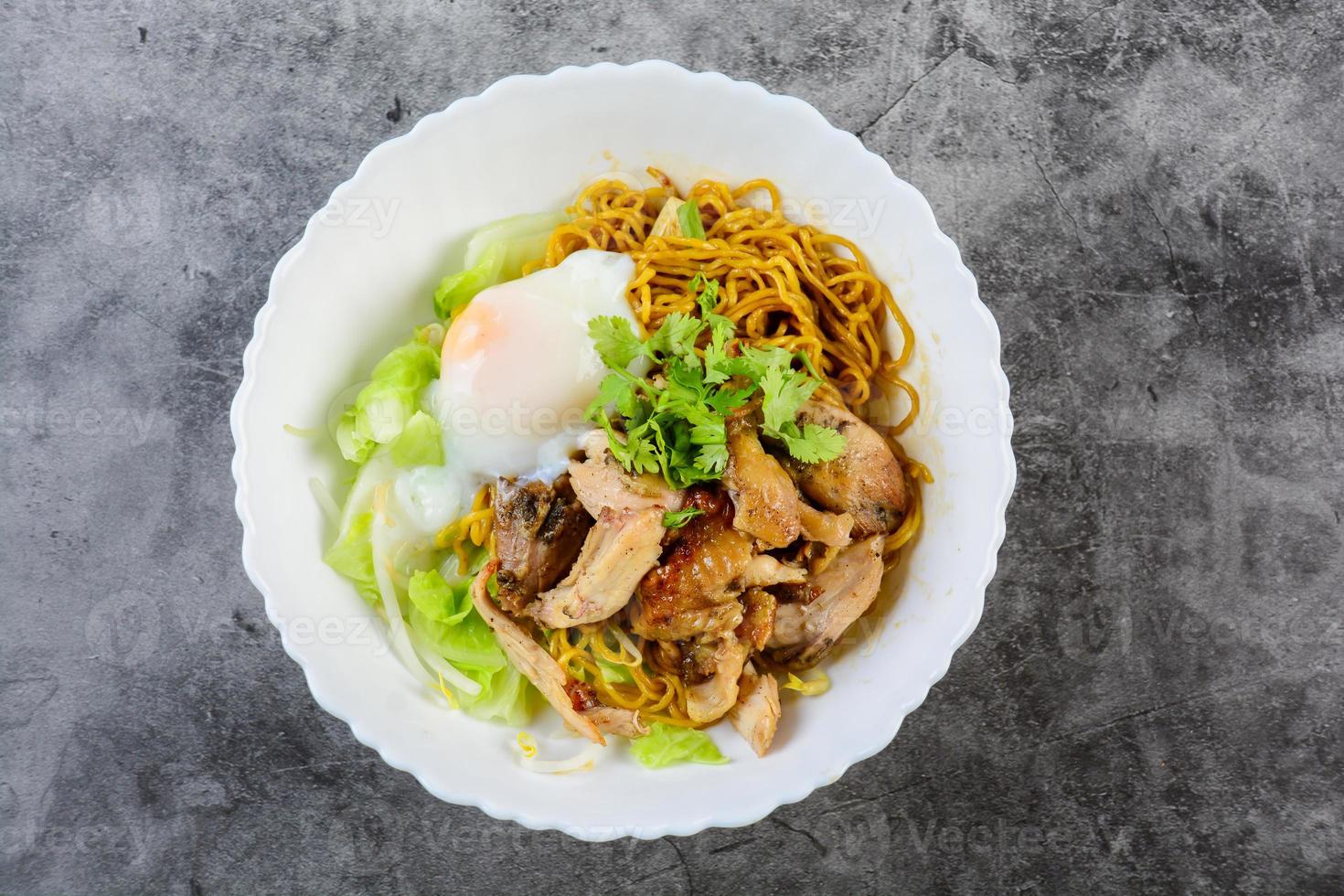 Egg noodles served dry with roasted honey chicken and soft-boiled onsen tamago eggs photo