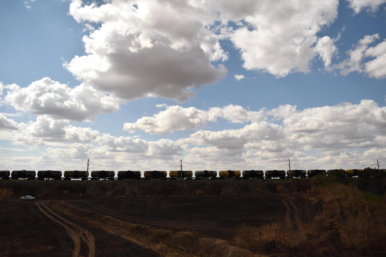 a long freight train rides under a cloudy sky photo