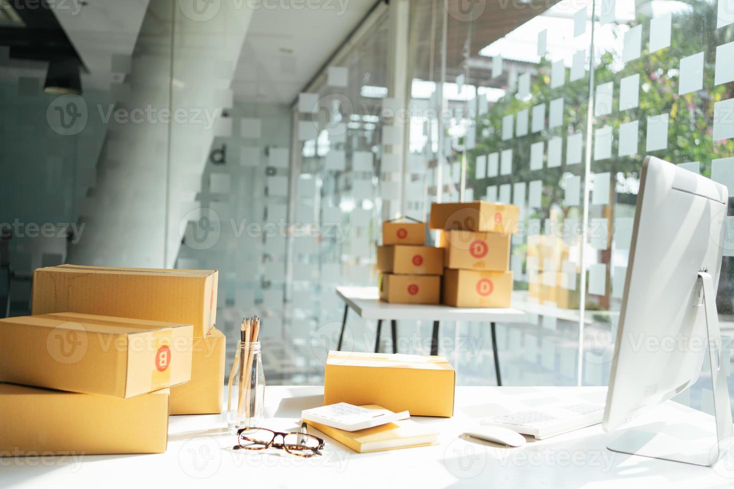 shipping and delivery concept, table with laptop computer and shipping boxes in post office. photo