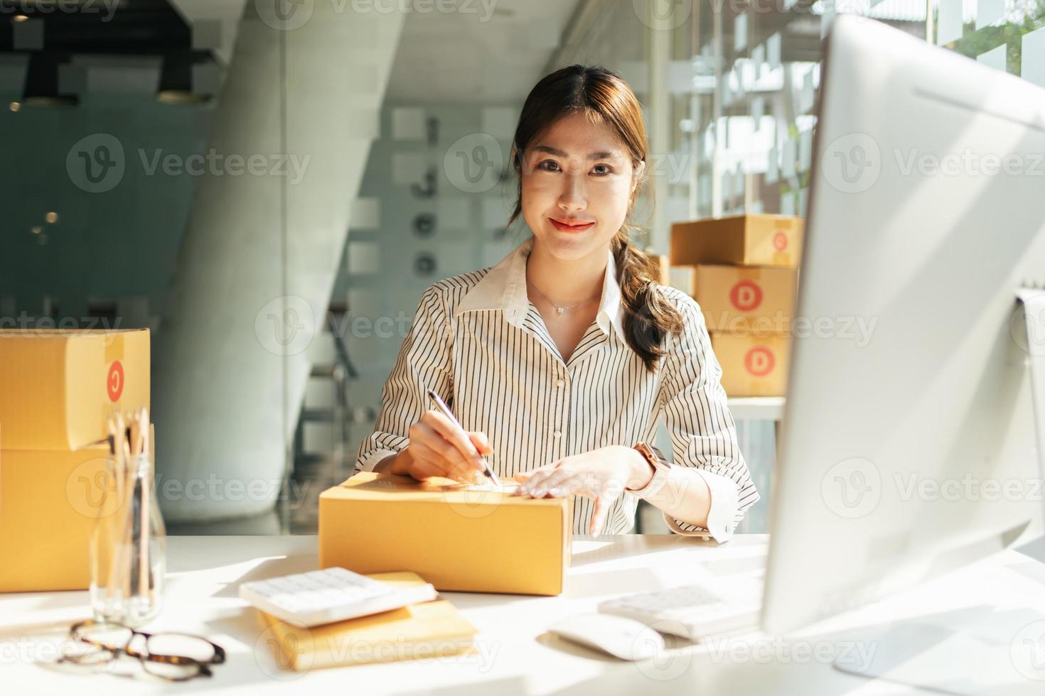 Starting small businesses SME owners female entrepreneurs Write the address on receipt box and check online orders to prepare to pack the boxes, sell to customers, sme business ideas online. photo