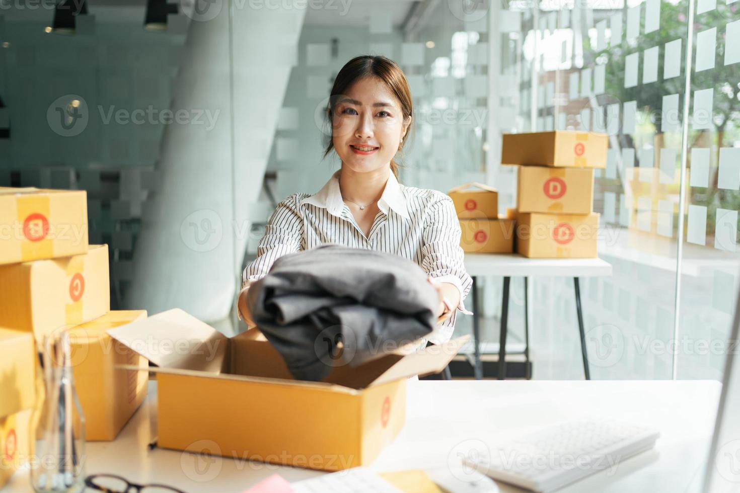 Portrait young attractive asia female owner startup business  work happy with box at home prepare parcel delivery in sme supply chain, procurement, omnichannel commerce online concept. photo