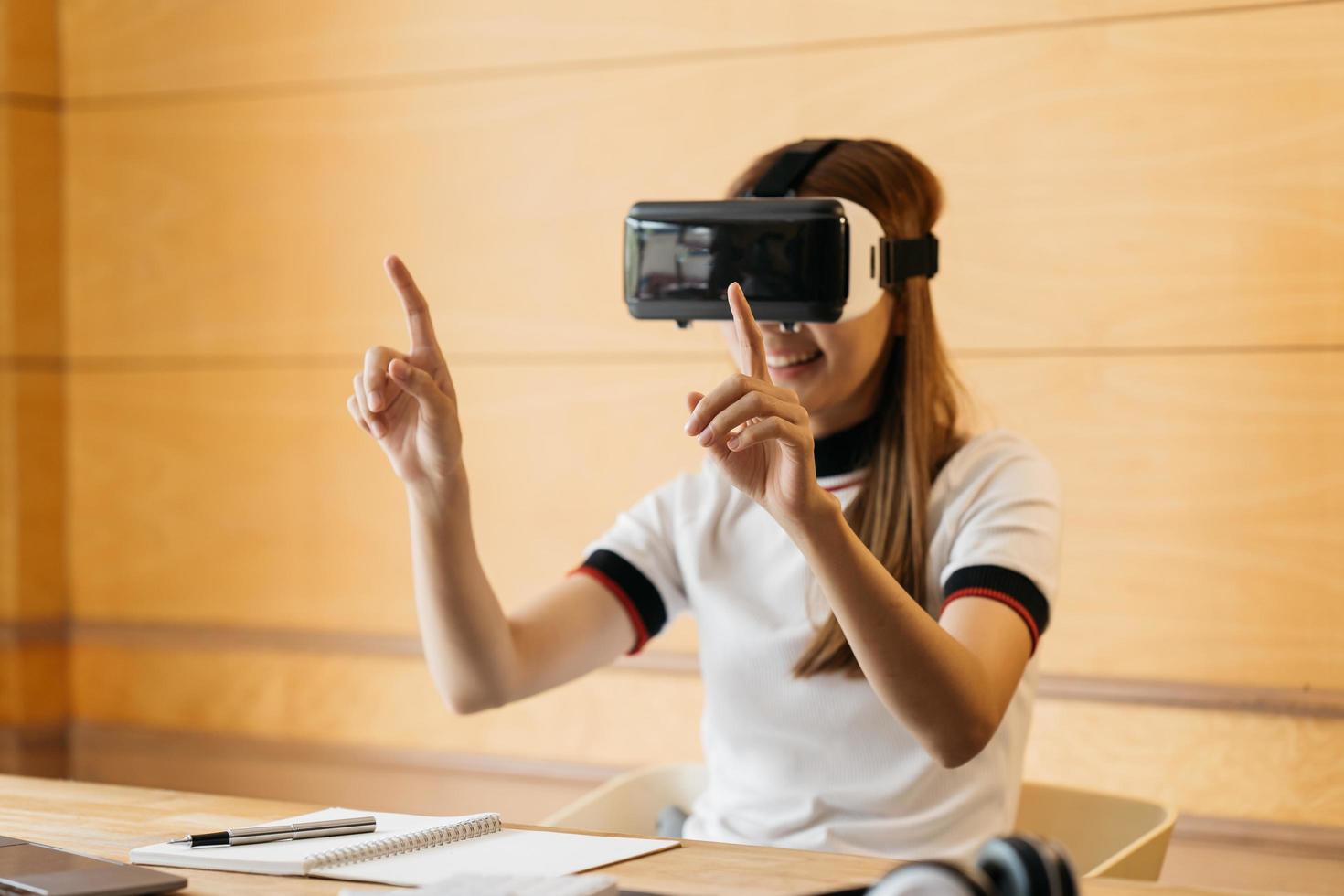 hermosa niña sonriente usa auriculares vr y toque interactivo por aire. dispositivo de gafas de auriculares vr. mujer de negocios asiática controlada por realidad virtual. foto