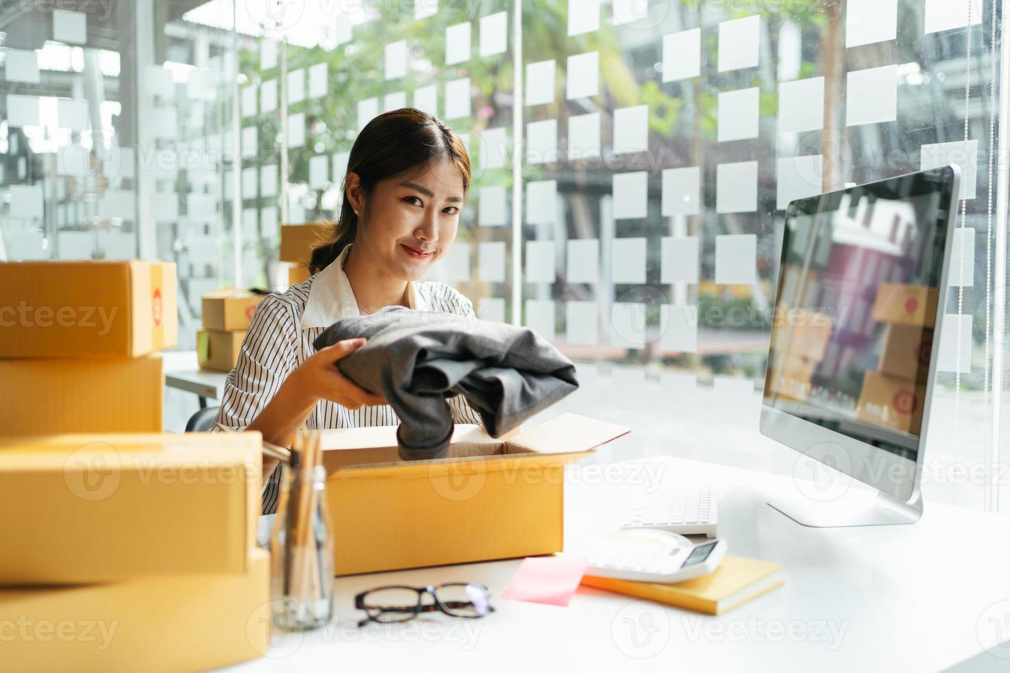 Retrato joven y atractiva propietaria de asia puesta en marcha trabajo de negocios feliz con caja en casa preparar entrega de paquetes en la cadena de suministro de pymes, adquisiciones, concepto de comercio omnicanal en línea. foto