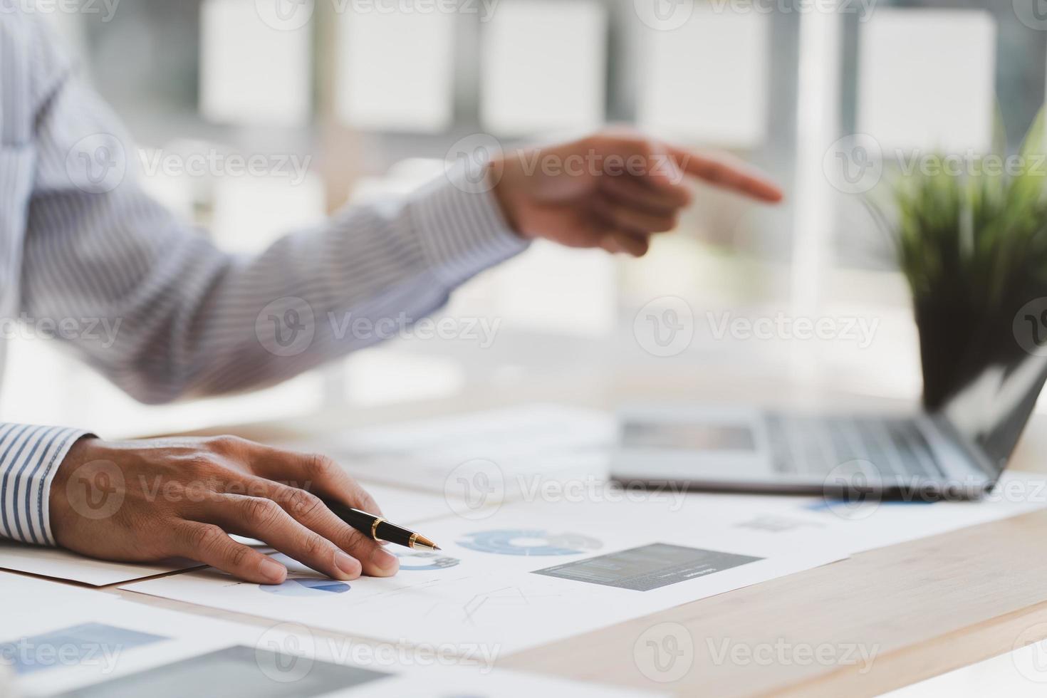 Manager is using a laptop computer while analyzing the company's financial statements on the screen. photo