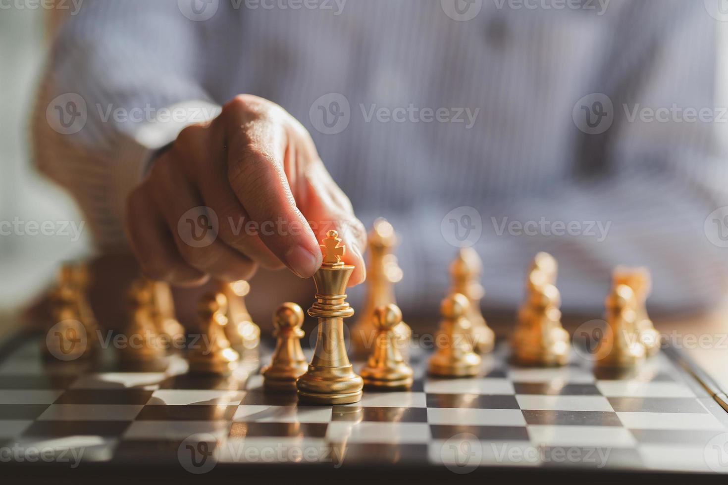 businessman hand moving gold Chess King figure and Checkmate opponent during chessboard competition. Strategy, Success, management, business planning, disruption and leadership concept photo