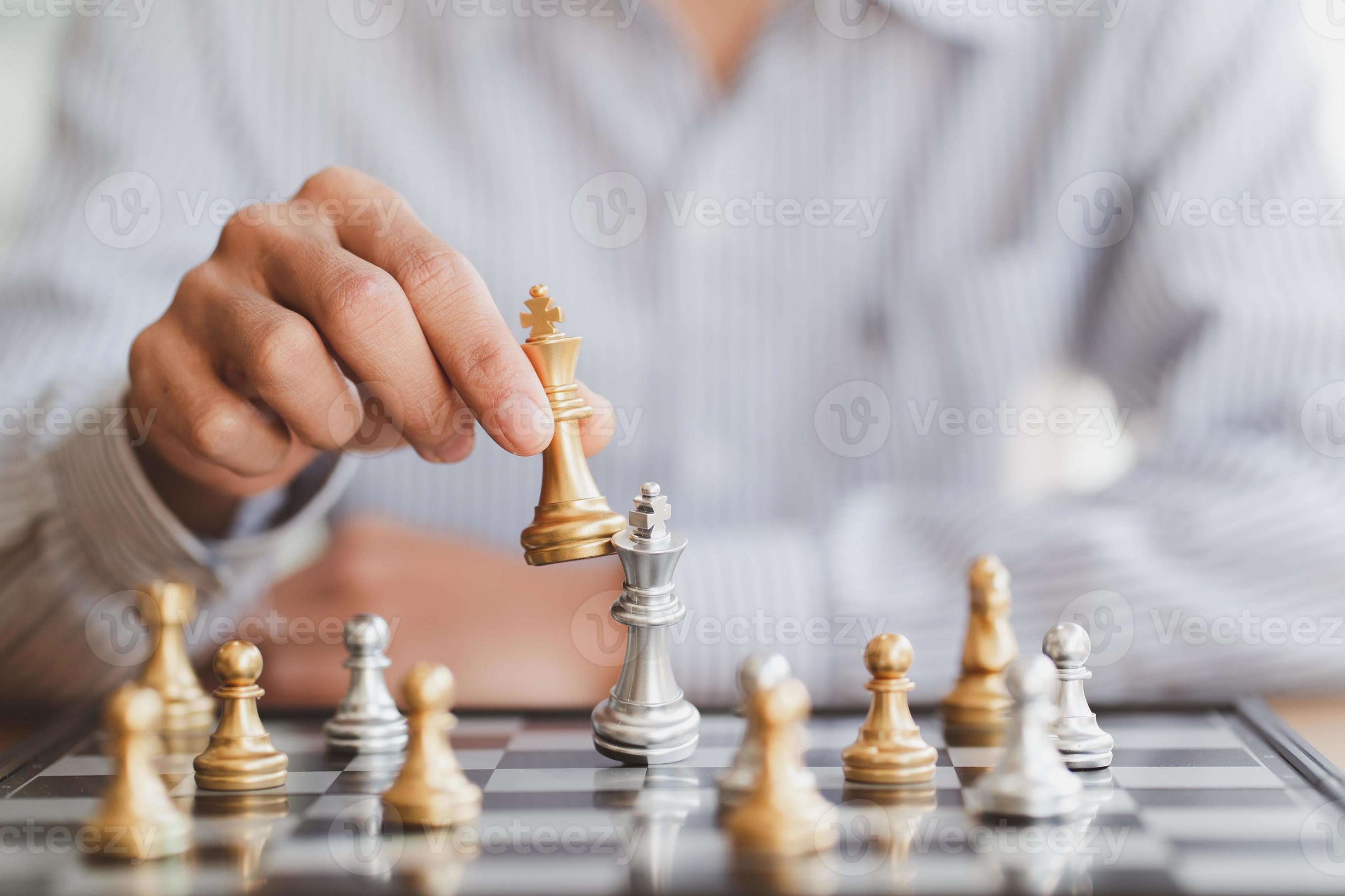 Close up of hands of a business man moving king golden chess to defeat  opponent the chess game is development analysis, strategy, and plan, the  management or leadership concept. 22804709 Stock Photo