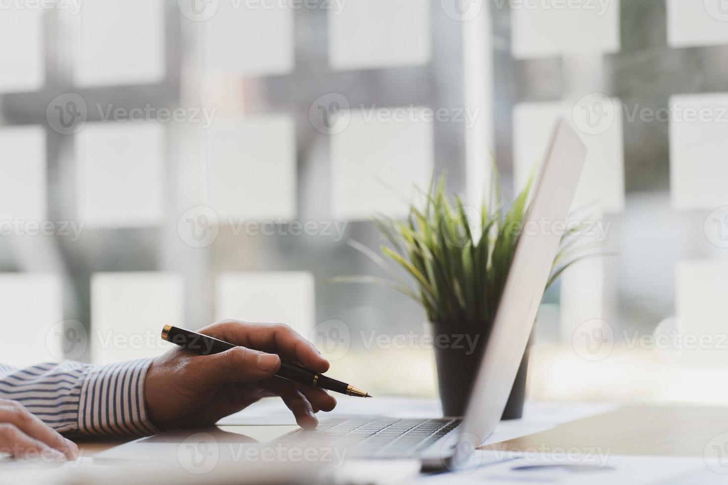 hombre de negocios que trabaja en la oficina con documentos y gráficos, información financiera y computadora portátil. foto