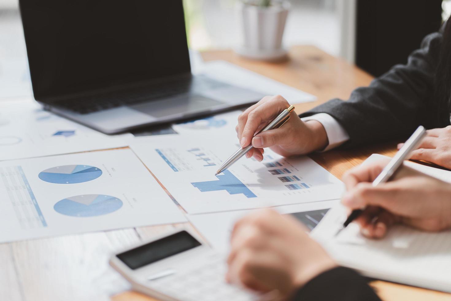 empresarios discutiendo las tablas y gráficos que muestran los resultados de su exitoso trabajo en equipo foto