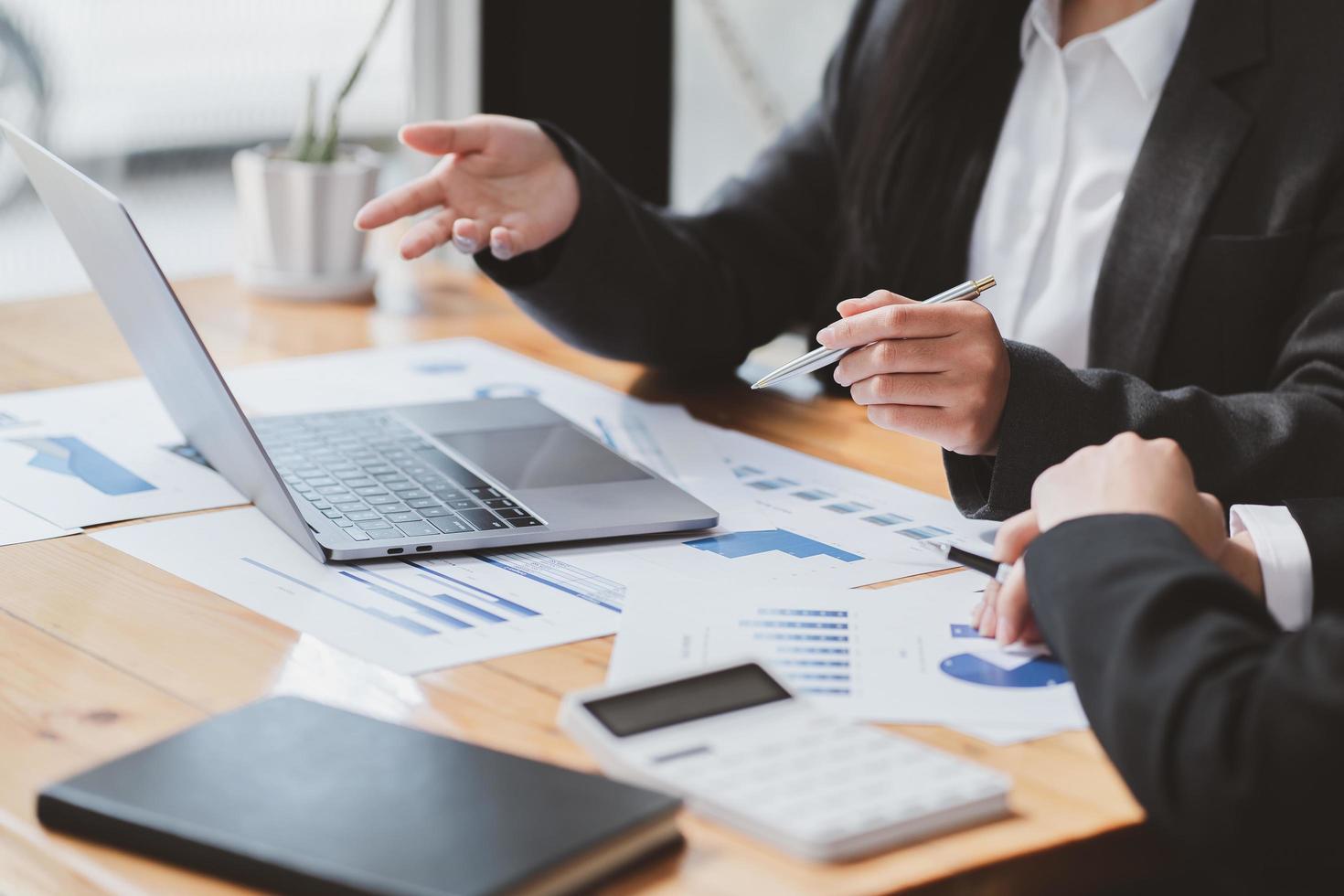 empresarios discutiendo las tablas y gráficos que muestran los resultados de su exitoso trabajo en equipo foto