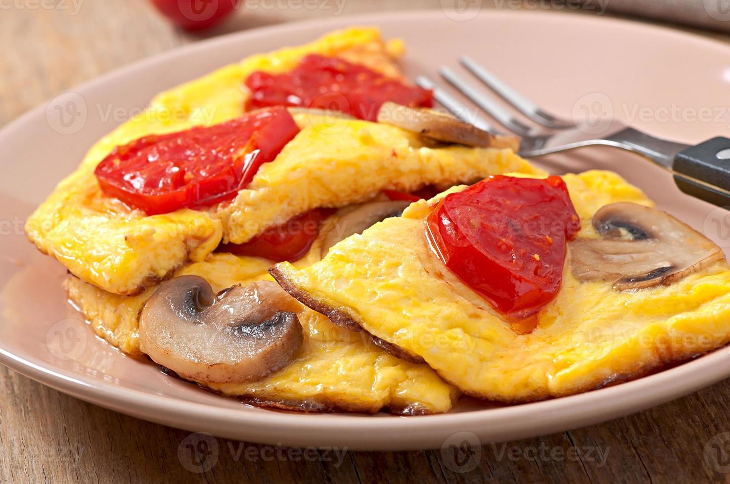 Delicious omelet with tomatoes and mushrooms for breakfast photo