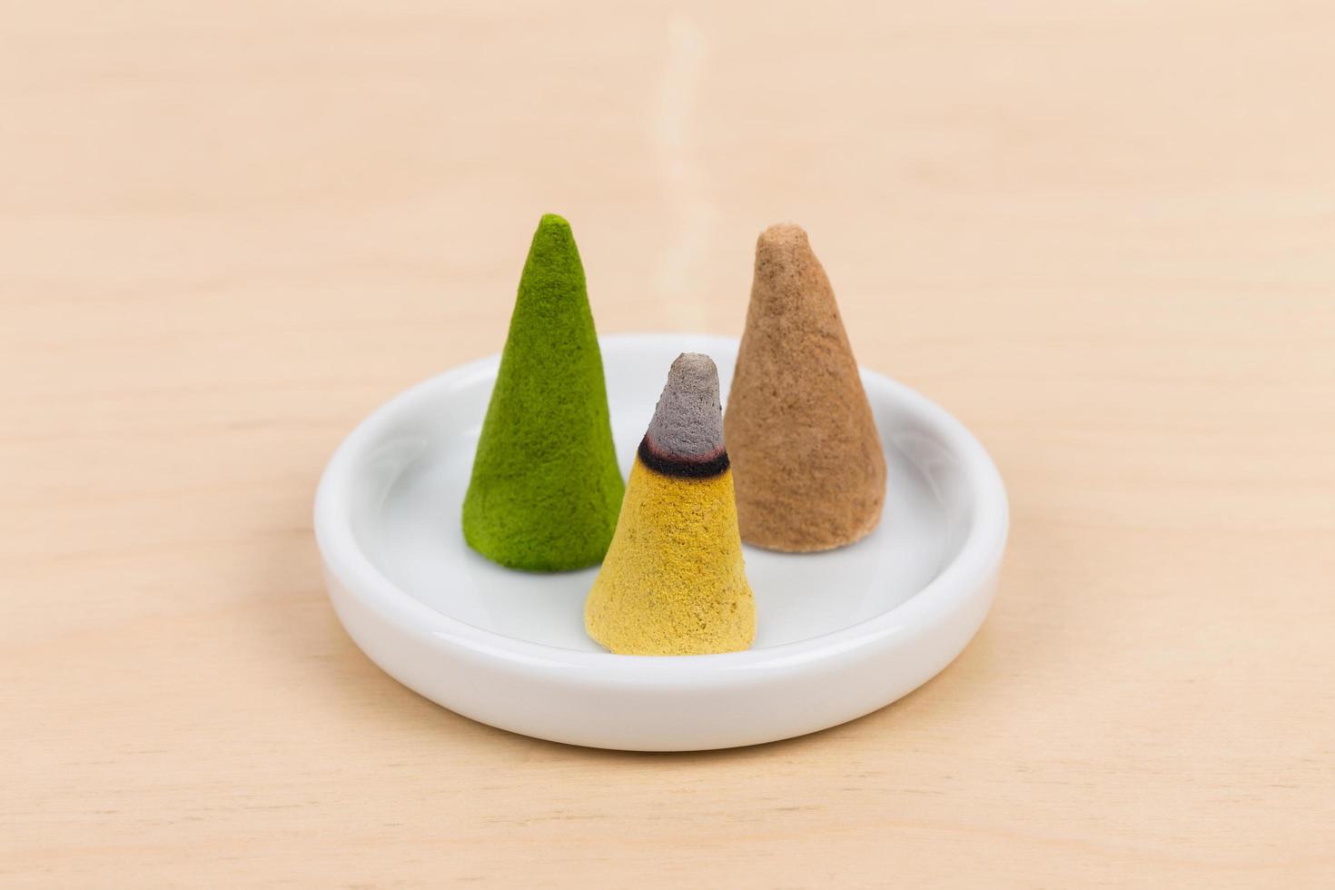 Burning incense cone on plate photo