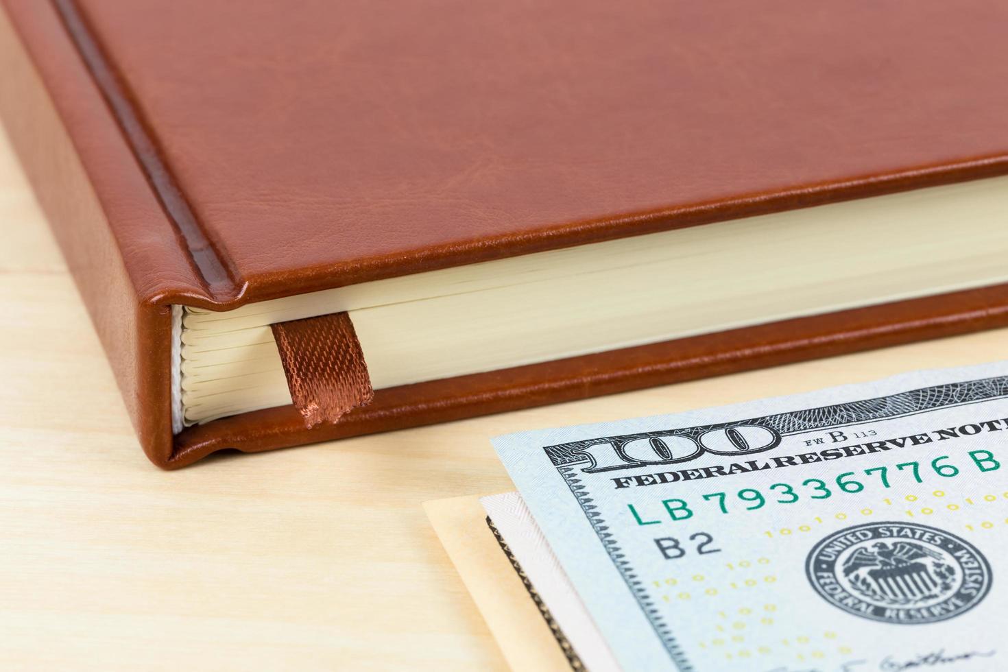 Notebook and dollar banknote on wooden desk photo