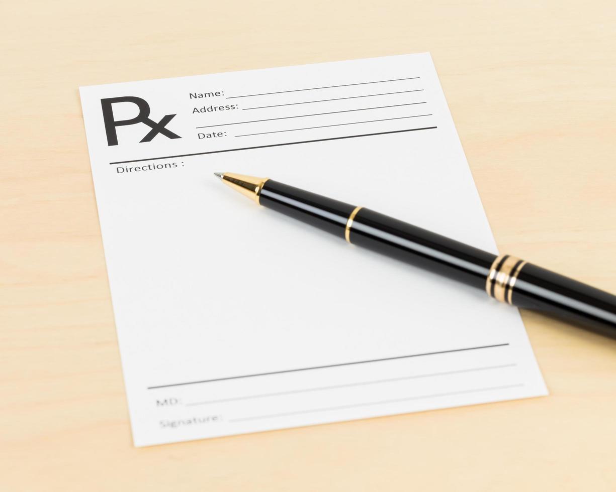 Blank prescription and pen, document is mock-up photo