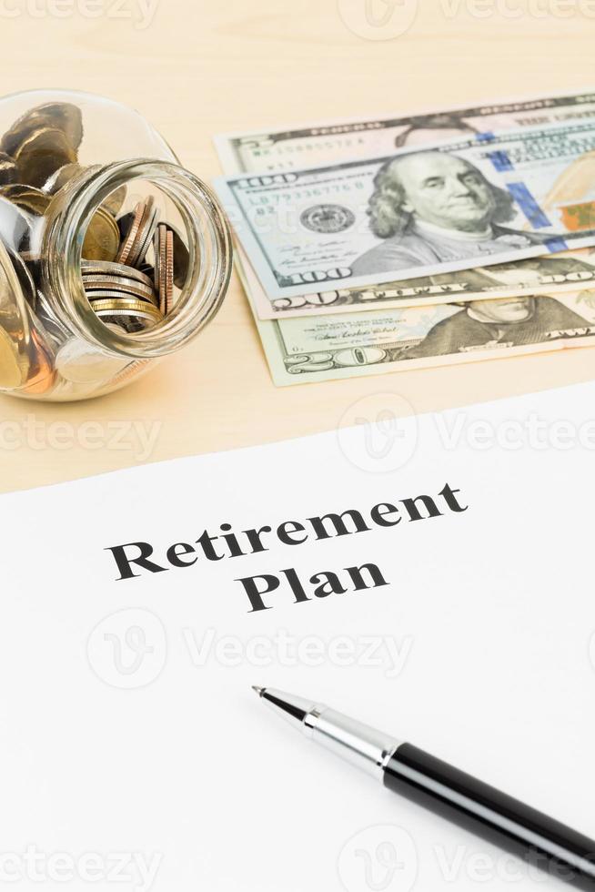 Retirement plan with banknote, coin jar, and pen photo