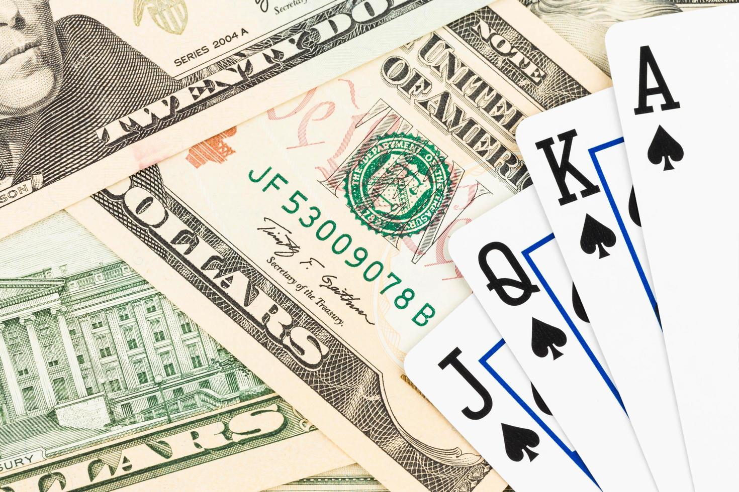 Royal flush poker playing cards on dollar banknote photo