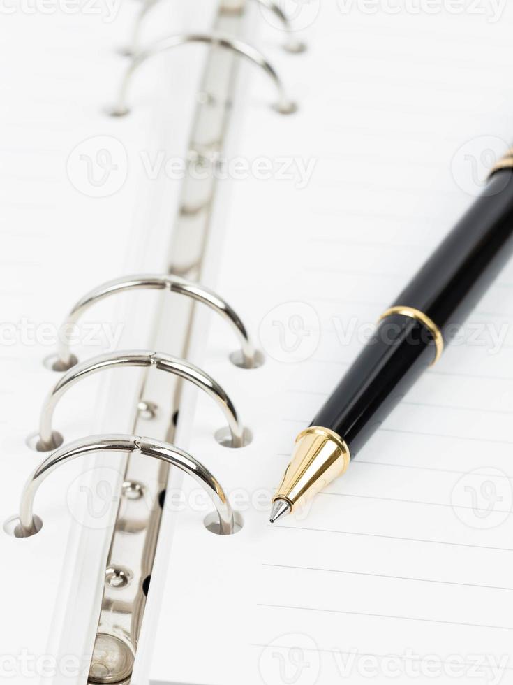 bolígrafo en el cuaderno organizador de páginas en blanco foto