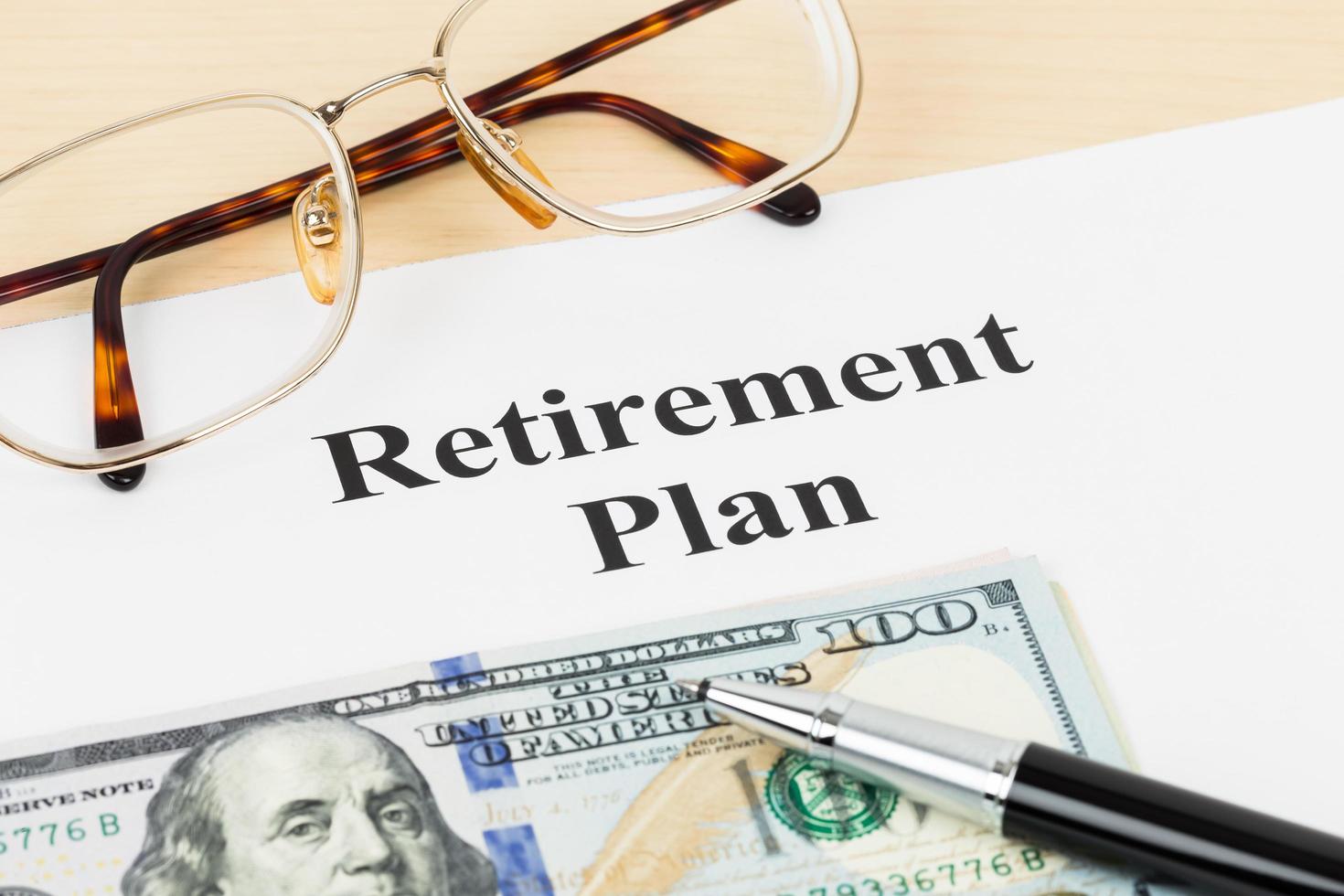 Retirement plan with banknote, glasses, and pen photo
