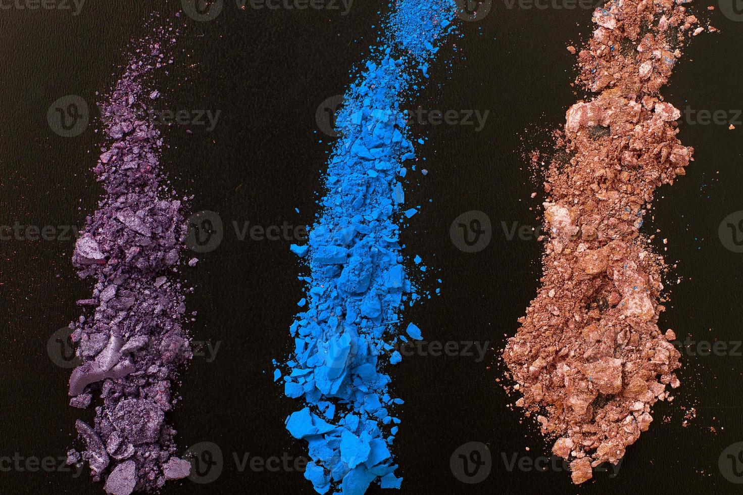 Eye shadows on black background. Crushed cosmetic. Make up cosmetics. Top view and mock up photo