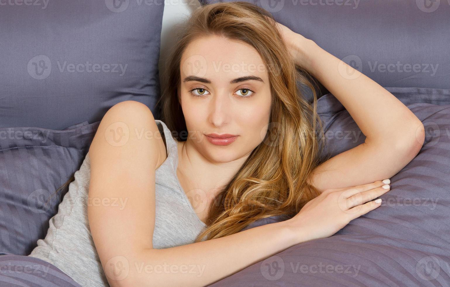 chica joven después de dormir en la cama retrato de cerca foto