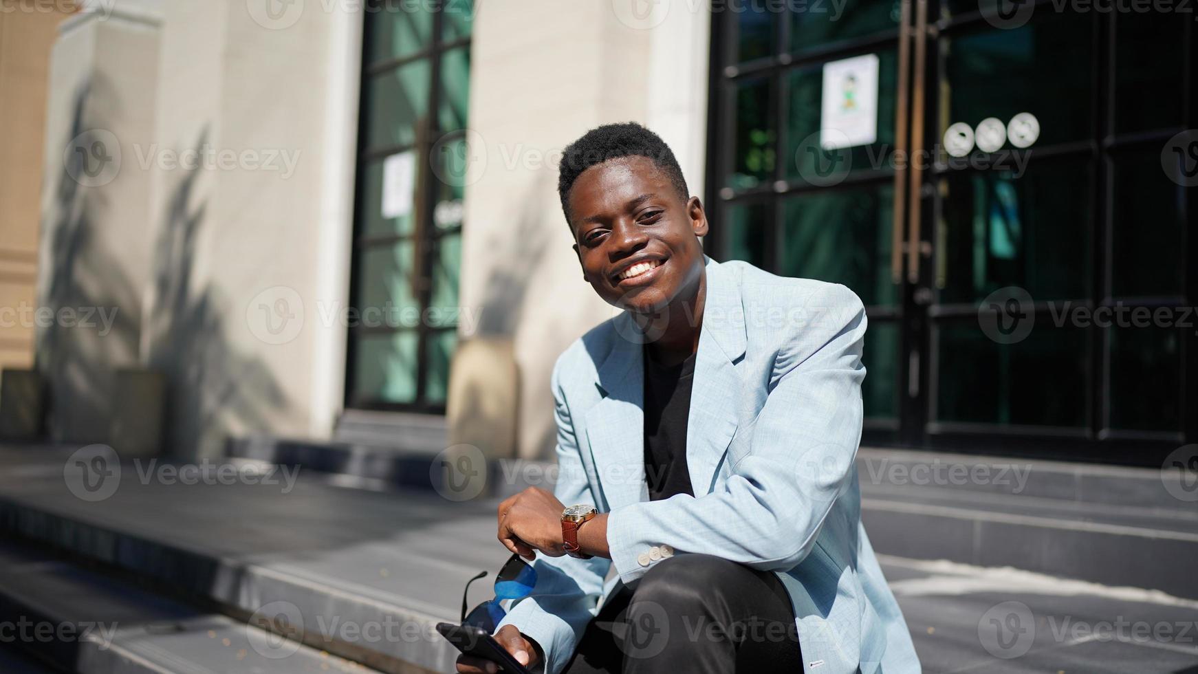 hombre afroamericano divirtiéndose caminando en el centro de la ciudad - joven feliz disfrutando del tiempo una puesta de sol al aire libre - estilo de vida de generación milenaria y concepto de actitud positiva de la gente foto