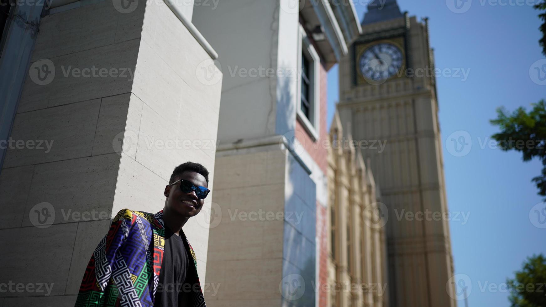 hombre afroamericano divirtiéndose caminando en el centro de la ciudad - joven feliz disfrutando del tiempo una puesta de sol al aire libre - estilo de vida de generación milenaria y concepto de actitud positiva de la gente foto