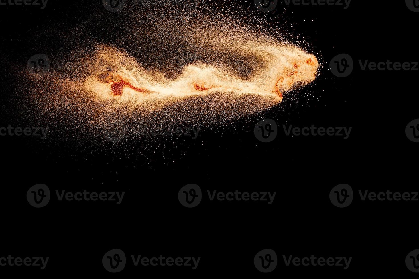 Abstract sand cloud.Brown sand splash against dark background. Brown dust explosion. photo