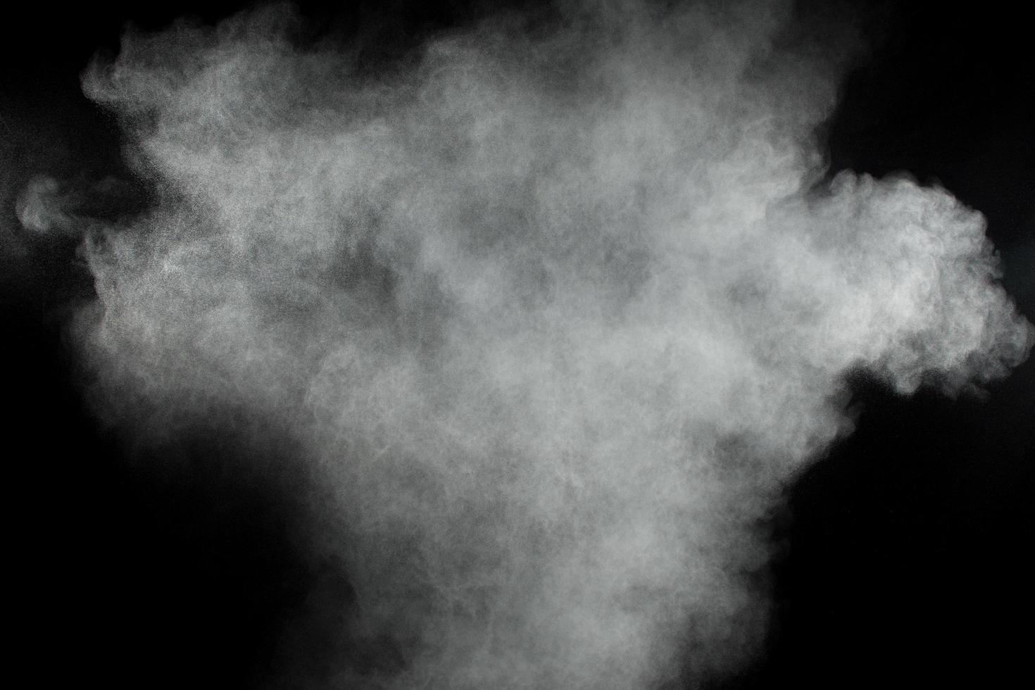 nubes de explosión de polvo blanco. congelar el movimiento de partículas de polvo blanco sobre fondo negro. foto