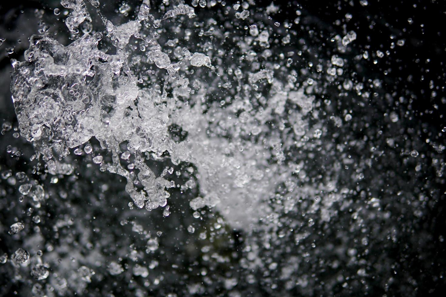 salpicaduras de agua sobre fondo negro. salpicaduras de agua con estilo. aislado sobre fondo negro. foto