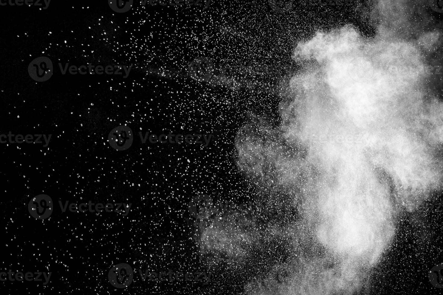 Bizarre forms of white powder explosion cloud against black background.White dust particles splash. photo