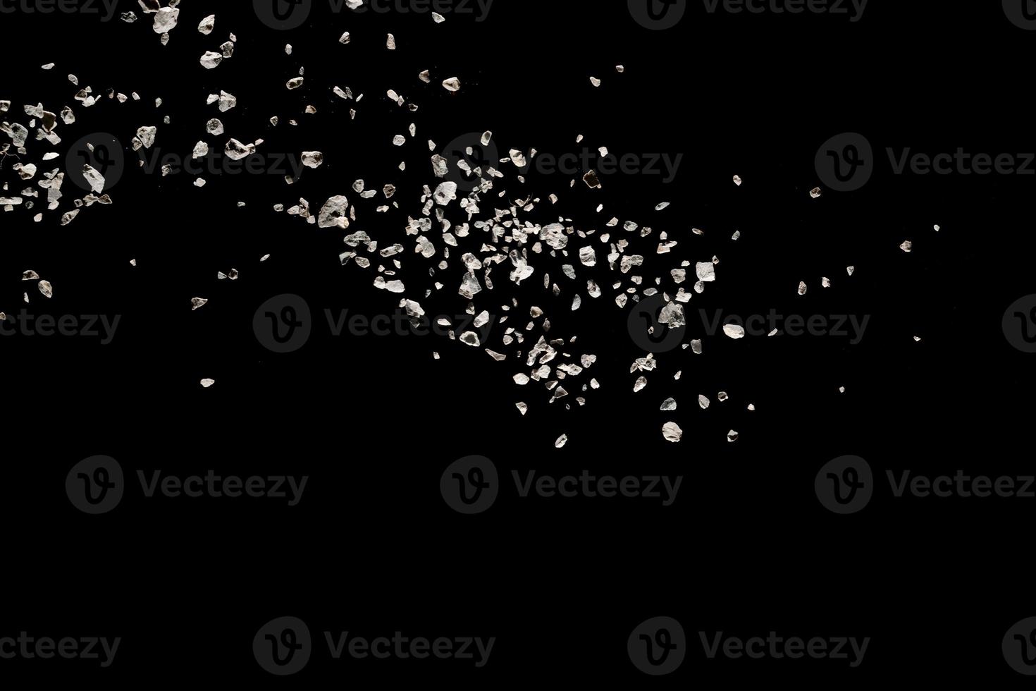 Split debris of stone exploding against black background. photo