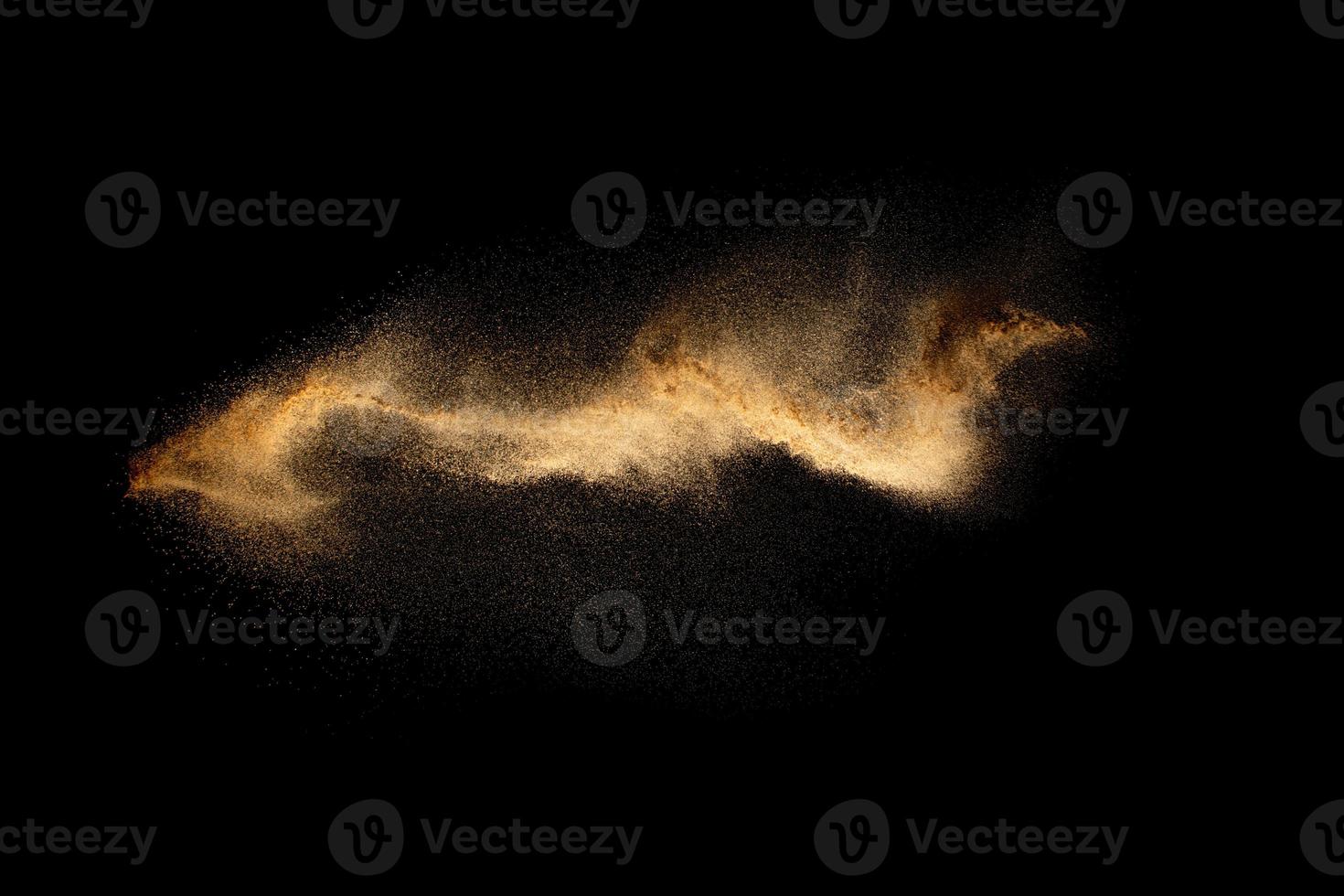 Abstract motion blurred brown sand background.Sandy explosion isolated on over dark background. photo