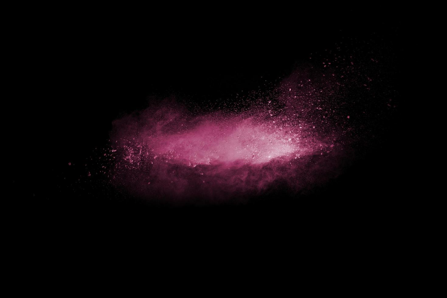 Pink dust particles splash on black background.Pink powder splash. photo