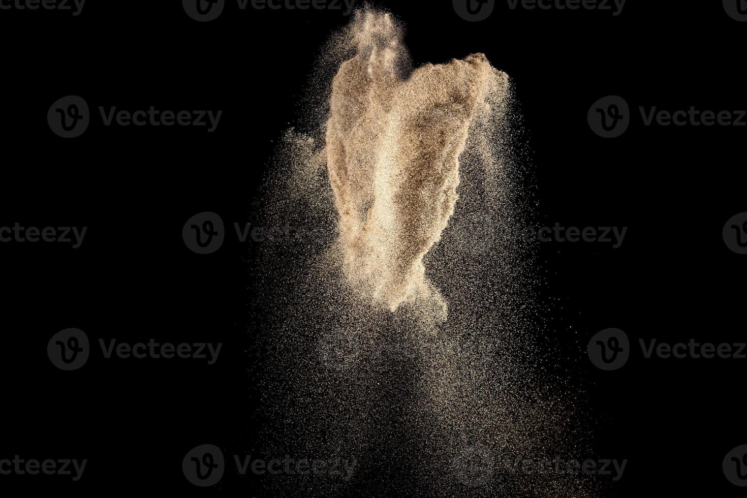 Brown color sand splash against black background. photo