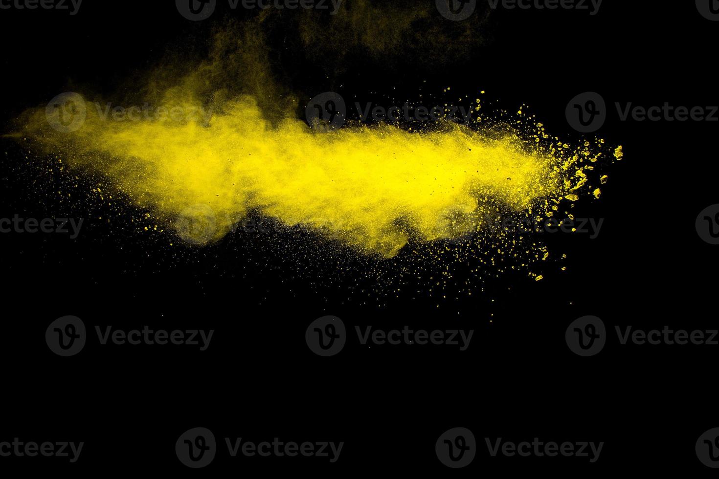 explosión de partículas de polvo amarillo sobre fondo negro. salpicadura de polvo amarillo. foto