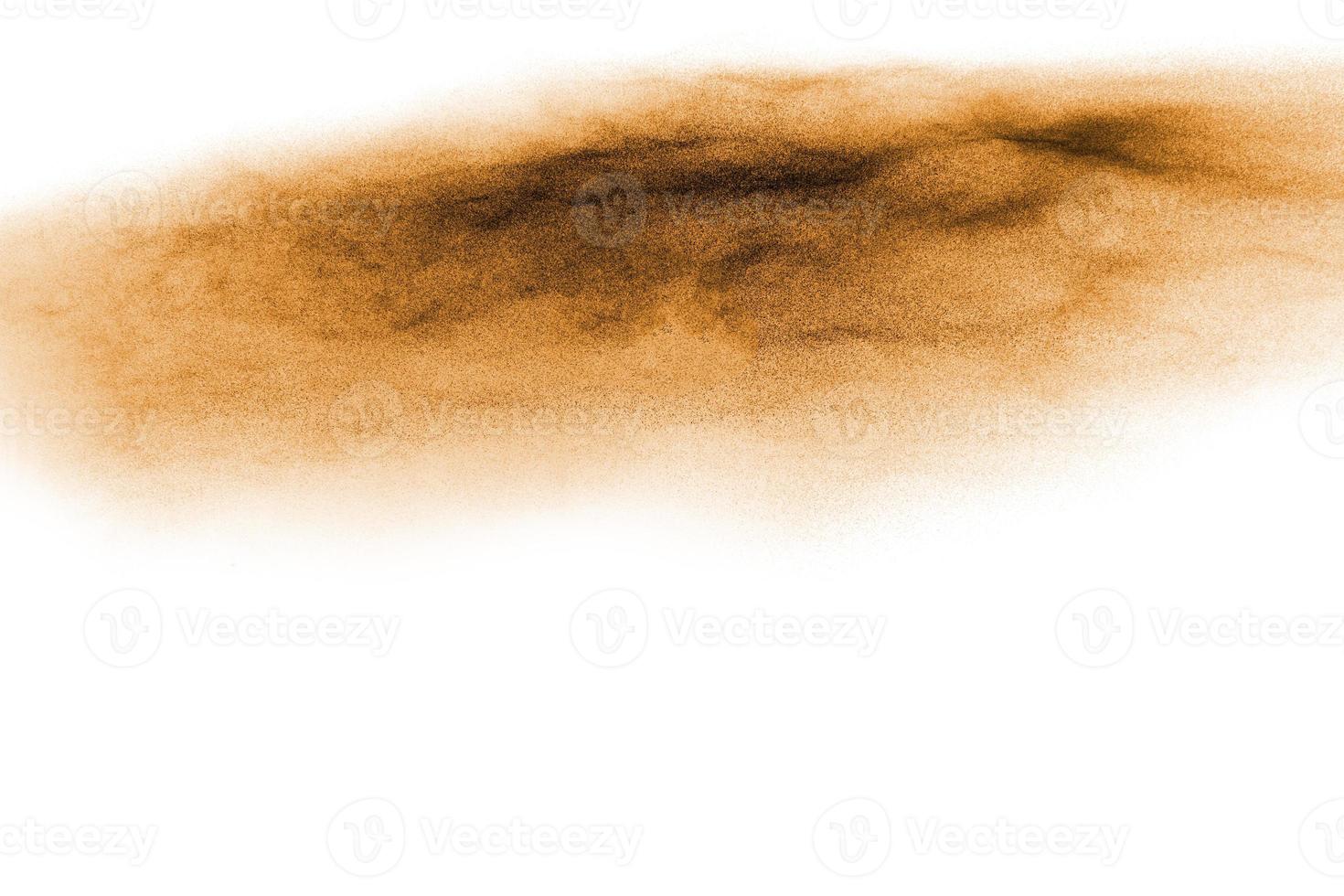 Golden sand explosion isolated on white background. Abstract sand cloud.Sandy fly wave in the air. photo