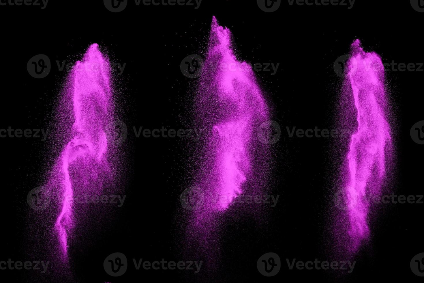 Pink particles splatter on black background. Pink powder exploding. photo