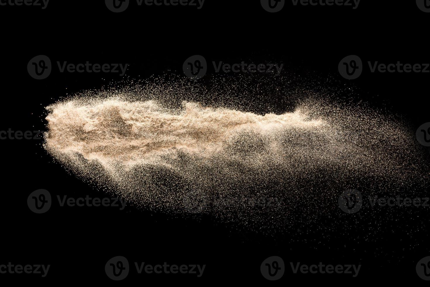 Dry river sand explosion. Golden colored sand splash against  black background. photo