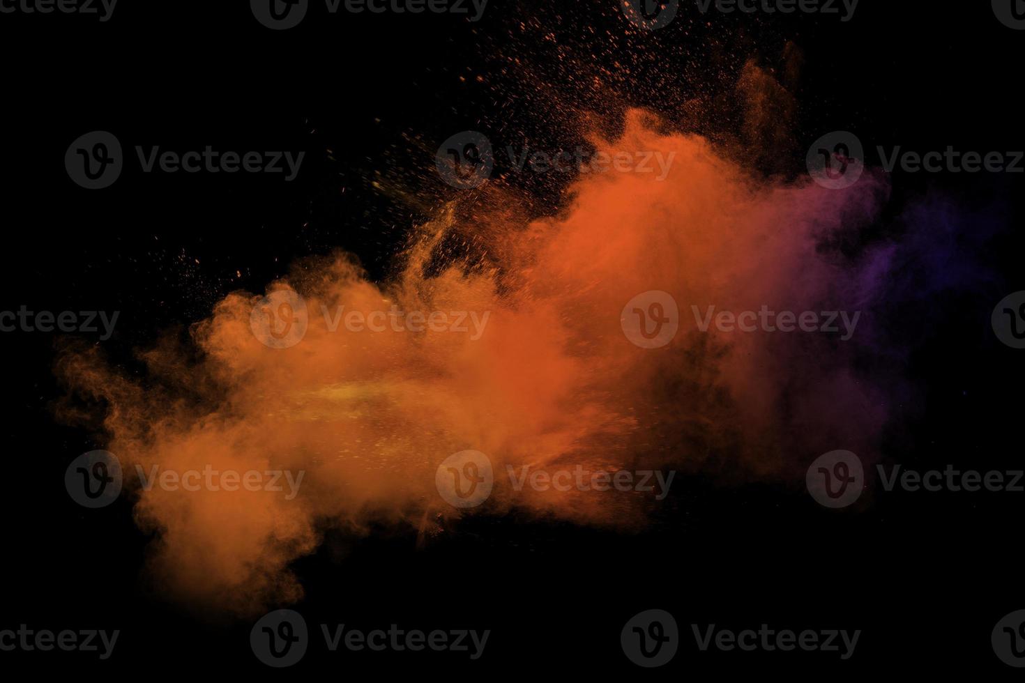 Abstract blurred motion of colorful dust particles on black background.Abstract hot tone color powder overlay texture. photo